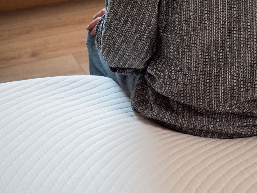 Tester zit op de Slome Originele Hybride matras met het golvende stiksel
