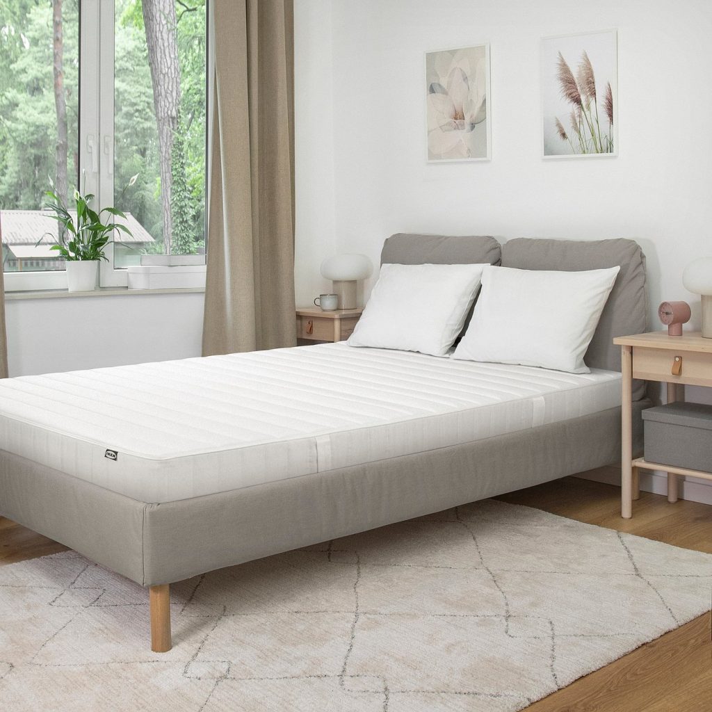 IKEA Aspsjökullen op een grijs gestoffeerd bed in een lichte slaapkamer