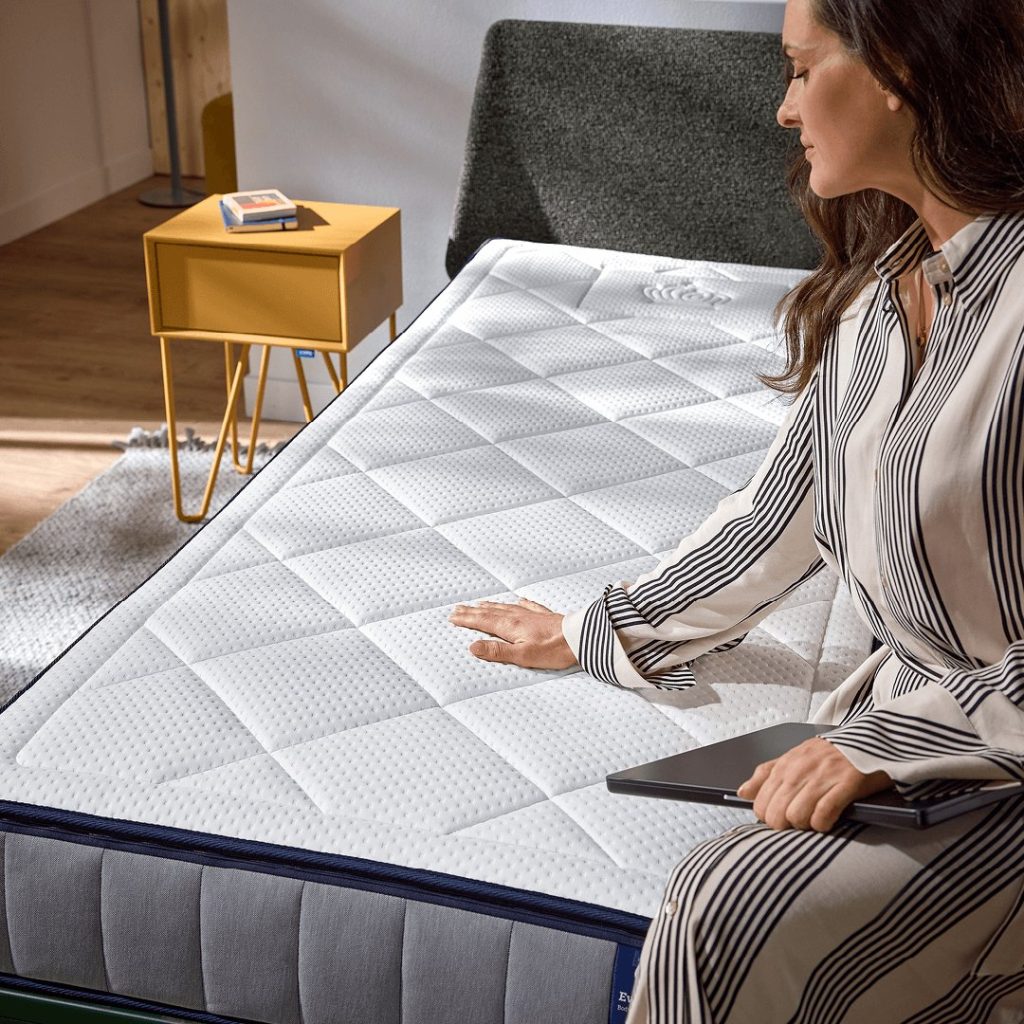 Vrouw zit op de rand van de Auping Evolve