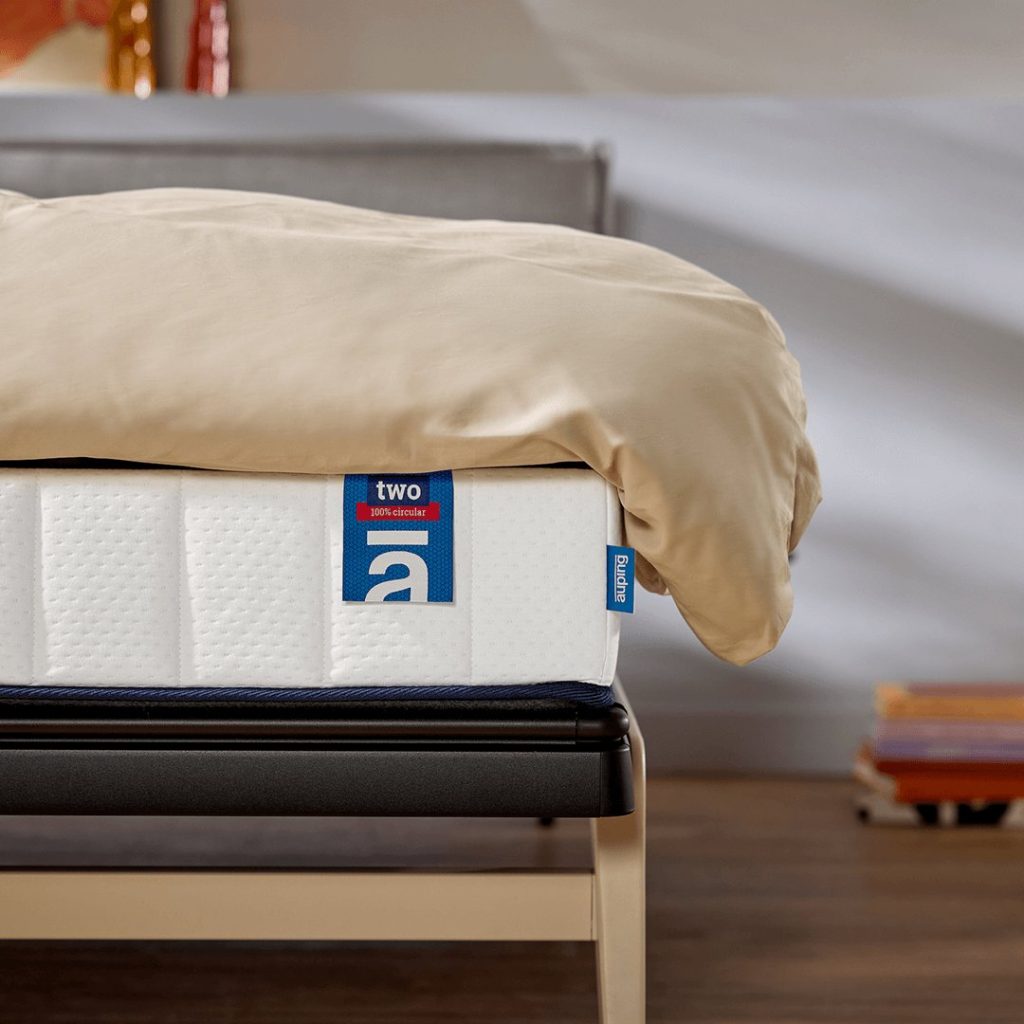 Auping Two op een houten bed met dekbed over de rand