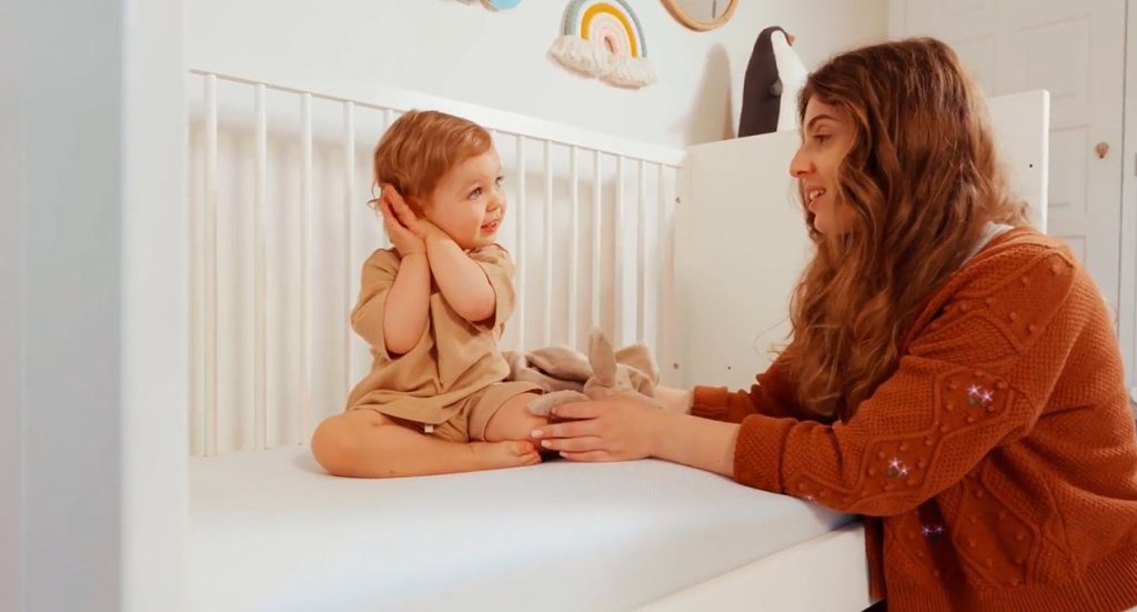 Moeder en baby bij een ledikant met het Emma kindermatras