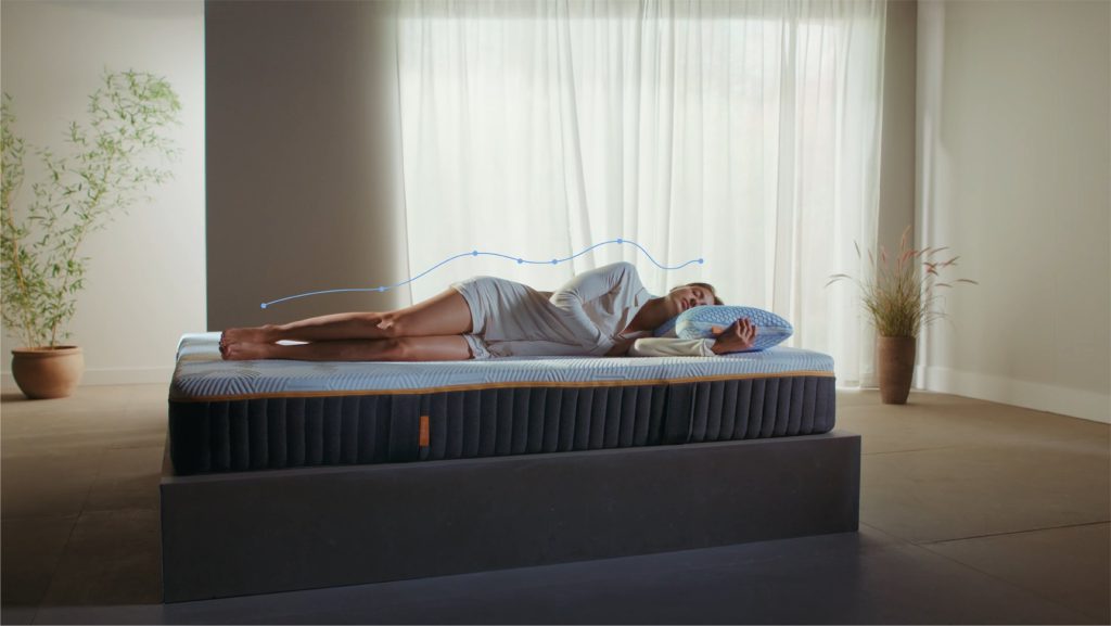 Vrouw slaapt op het Emma Original Elite matras in een lichte kamer