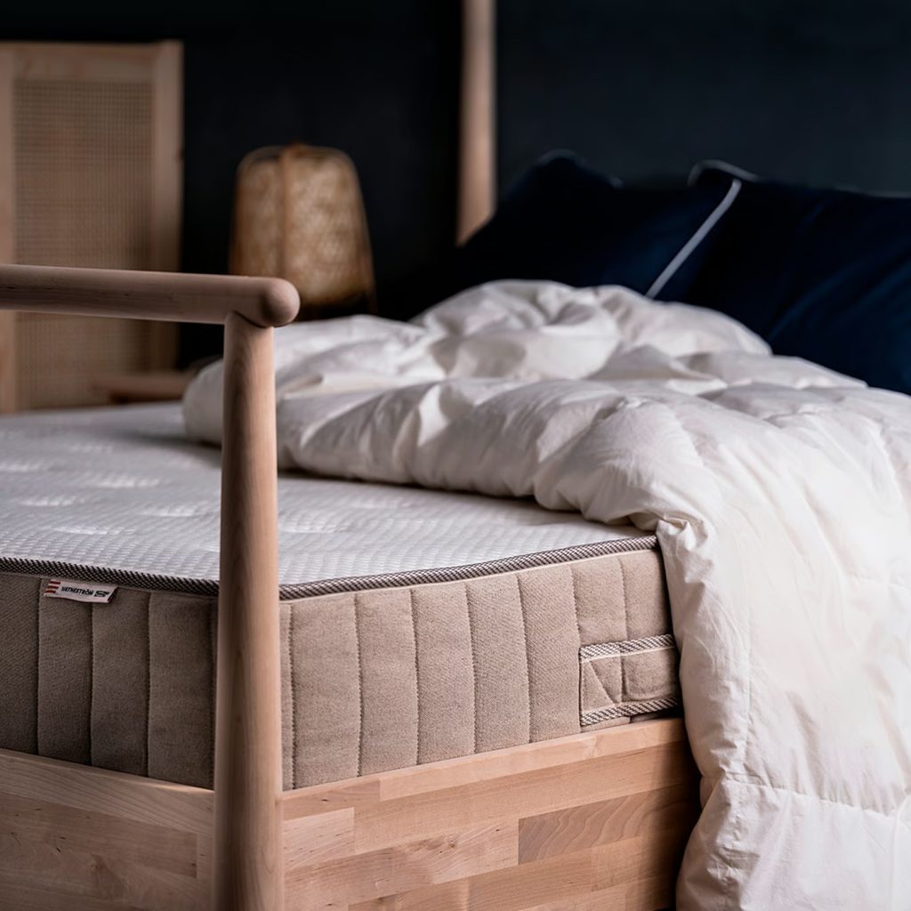 IKEA Vatneström op een houten bed met verfrommeld dekbed