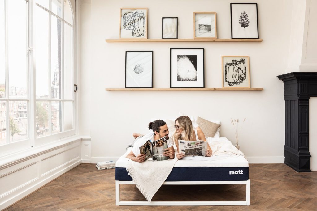 Stel zit op het Matt Sleeps matras in een lichte kamer